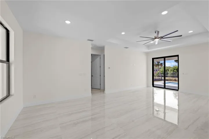 Unfurnished room featuring recessed lighting, a raised ceiling, baseboards, and ceiling fan