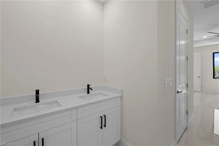 Bathroom featuring a sink, visible vents, marble finish floor, and double vanity