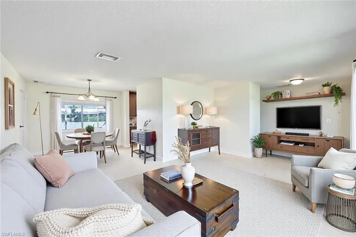 Living area with visible vents, baseboards, and a textured ceiling