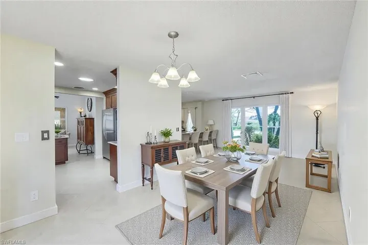 Dining area featuring light tile patterned floors, baseboards, and a chandelier