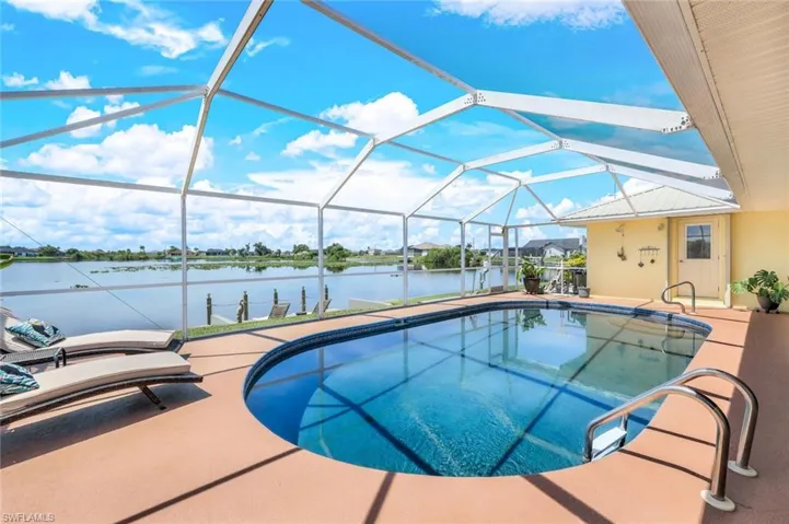 View of pool with a lanai and a water view