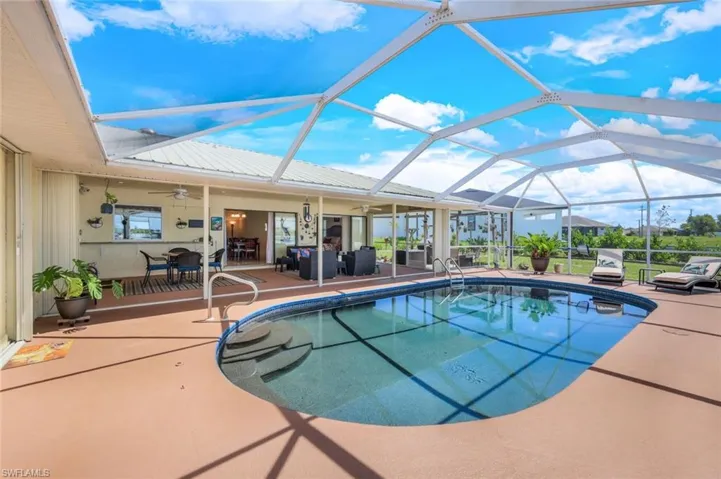 View of pool featuring a patio, screen enclosure, and ceiling fan