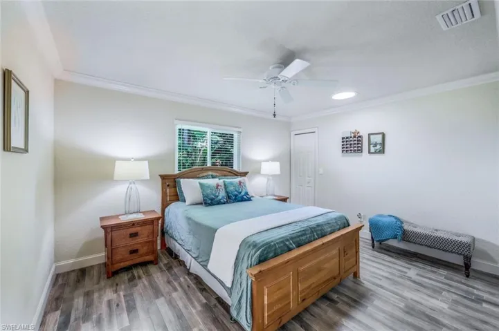 Bedroom with ceiling fan, tile flooring, and crown molding