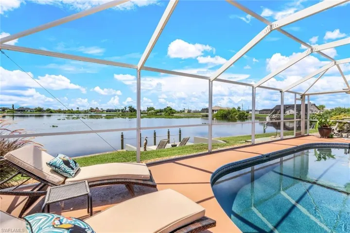 View of pool featuring screen enclosure and a water view