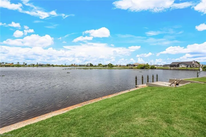 Dock area featuring a lawn and a water view