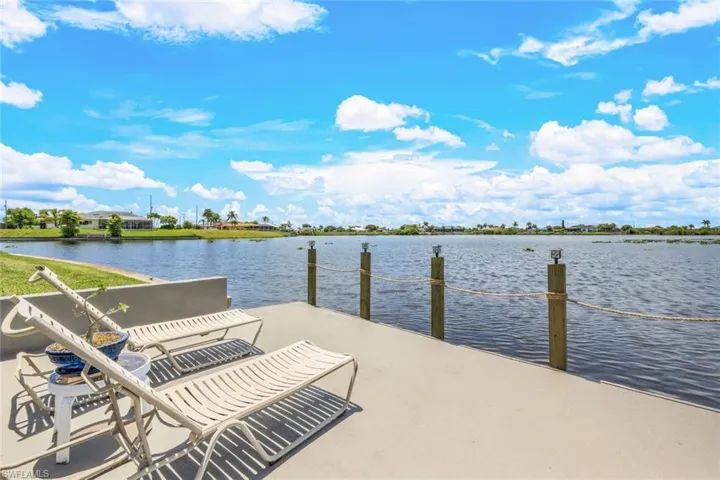 View of concrete dock featuring a water view. Hose spigot and electric at the dock.