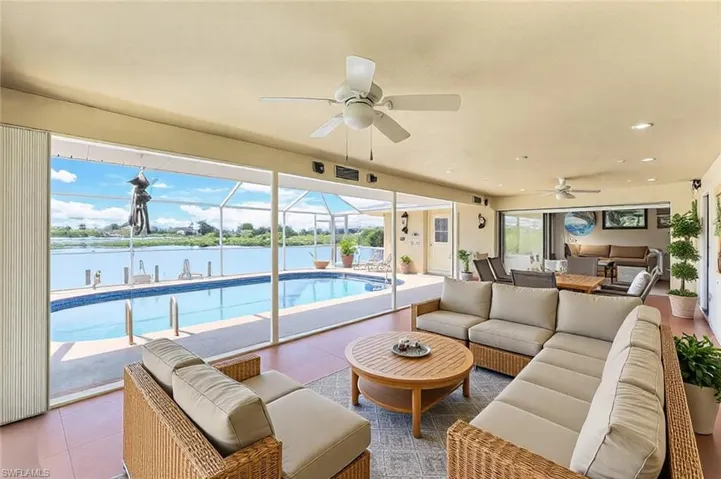 Tiled living room featuring a ceiling fan, visible vents, recessed lighting, a sunroom, and a water view