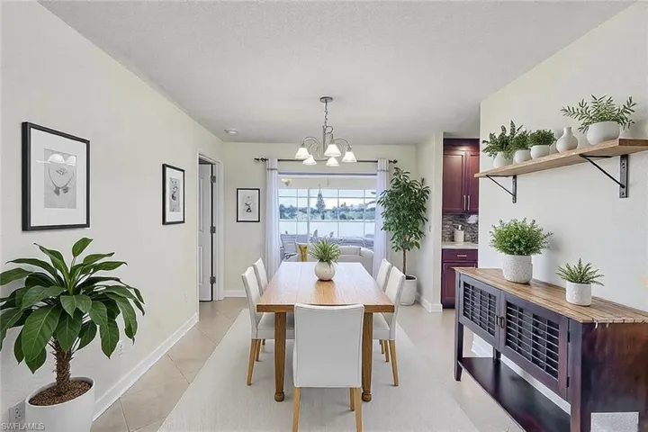 Dining room featuring a textured ceiling, light tile patterned flooring, baseboards, and a chandelier