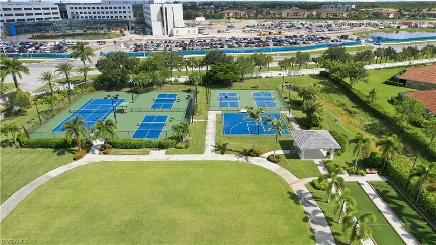 Multiple tennis courts, pickleball courts, basketball court, and a bocce ball court, surrounded by mature landscaping and walking paths