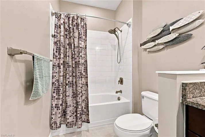 Tub and shower combination with white subway tile surround and bronze-finish fixtures