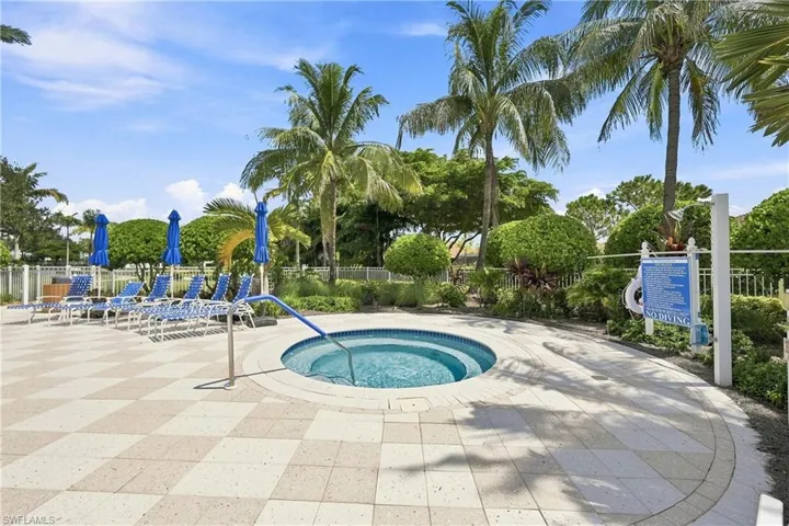 In-ground spa with tiled interior, surrounded by a checkerboard paver patio