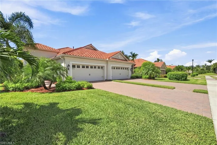 Mediterranean-inspired exterior with a tile roof and light-colored stucco finish