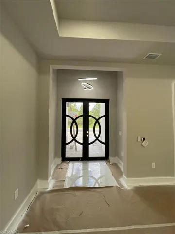 Foyer featuring french doors and a tray ceiling