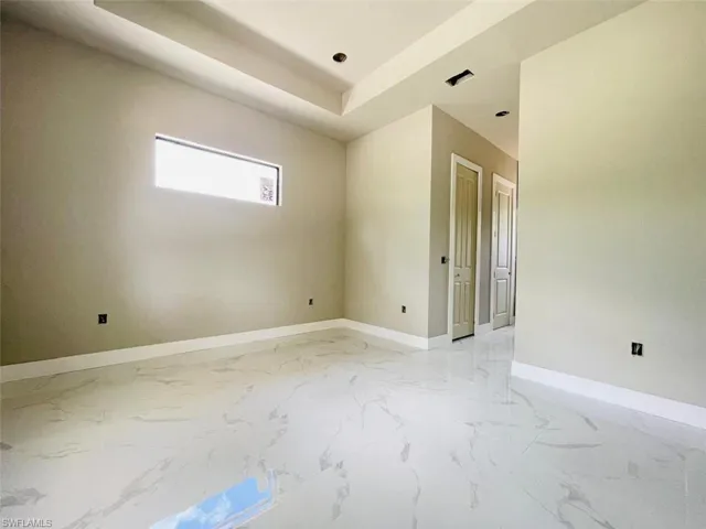 Spare room with baseboards, light marble finish flooring, and recessed lighting