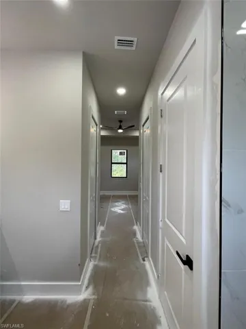 Hallway with baseboards and recessed lighting