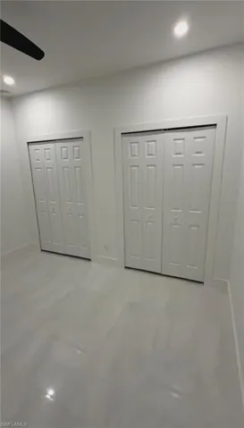 Unfurnished bedroom featuring multiple closets, ceiling fan, and recessed lighting