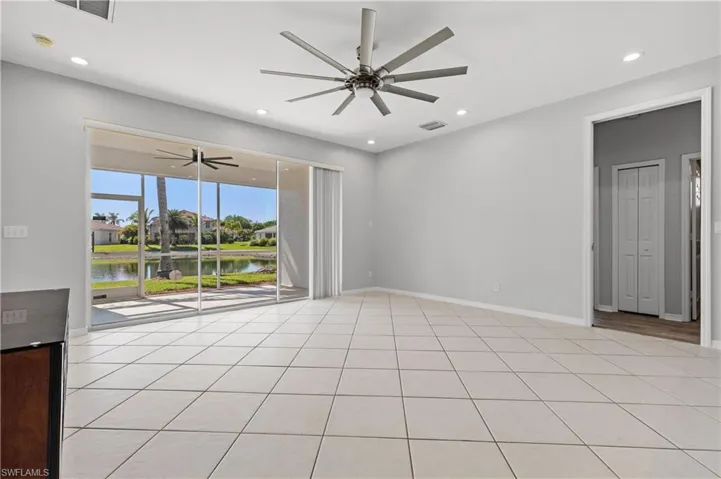 Empty room featuring a ceiling fan, recessed lighting, a water view, and light tile patterned floors