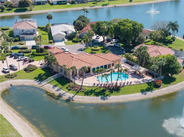 Aerial view of residential area with a nearby body of water and a pool area
