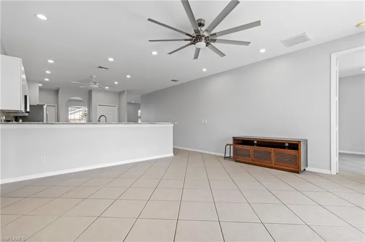 Unfurnished living room with ceiling fan and recessed lighting