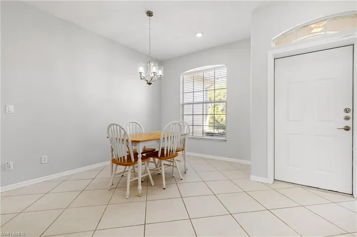 Dining space with suspended lighting and light tile patterned floors