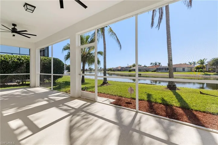 Unfurnished sunroom with a ceiling fan, a water view, and a residential view