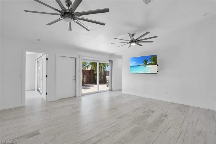 Empty room with ceiling fan and light hardwood / wood-style flooring