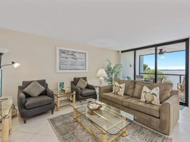 Living area featuring light tile patterned floors, a water view, and floor to ceiling windows