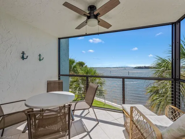 Balcony featuring a ceiling fan and a water view