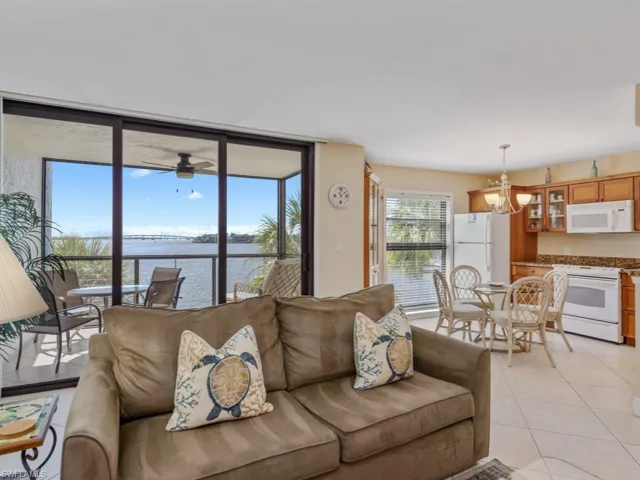 Living area with a water view, light tile patterned flooring, and a chandelier