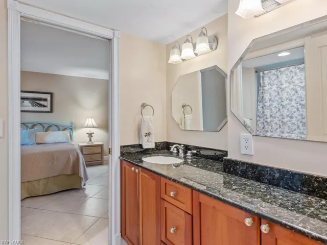 Full bath featuring vanity, light tile patterned flooring, ensuite bath, and curtained shower