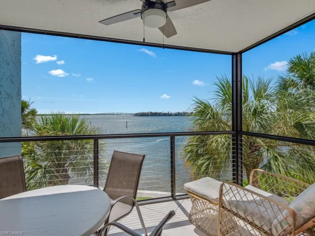 Balcony featuring a ceiling fan and a water view
