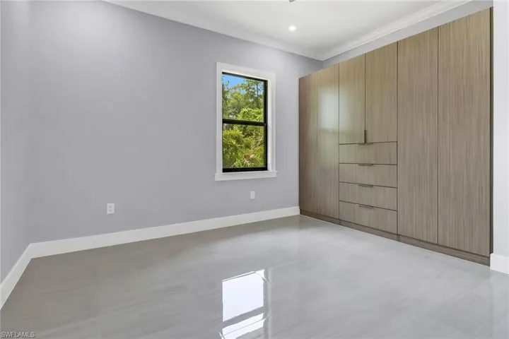 Unfurnished bedroom featuring ornamental molding and light tile patterned floors