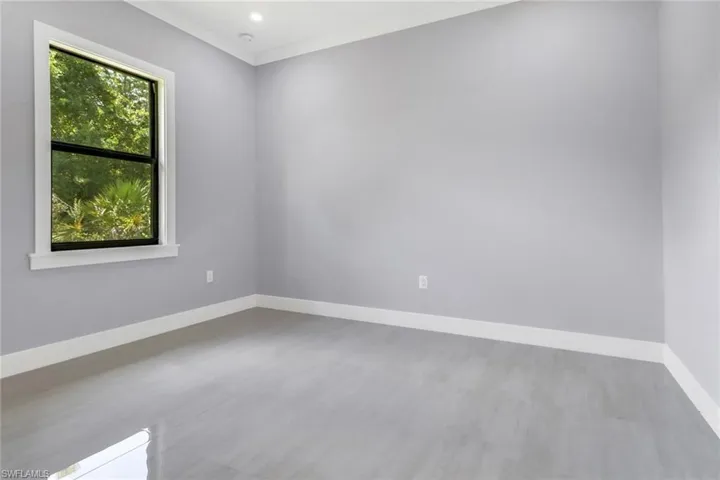 Unfurnished room with crown molding and hardwood / wood-style flooring
