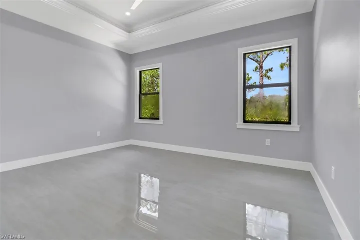 Empty room with crown molding, a tray ceiling, and hardwood / wood-style floors