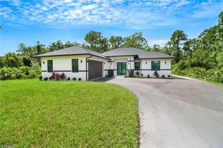 View of front of property featuring a garage and a front yard