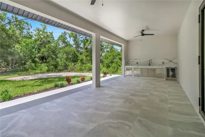 View of patio featuring sink, an outdoor kitchen, ceiling fan, and wine cooler