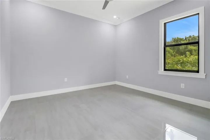 Spare room featuring wood-type flooring, crown molding, and ceiling fan