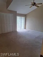 Unfurnished bedroom with ceiling fan, a closet, and dark carpet