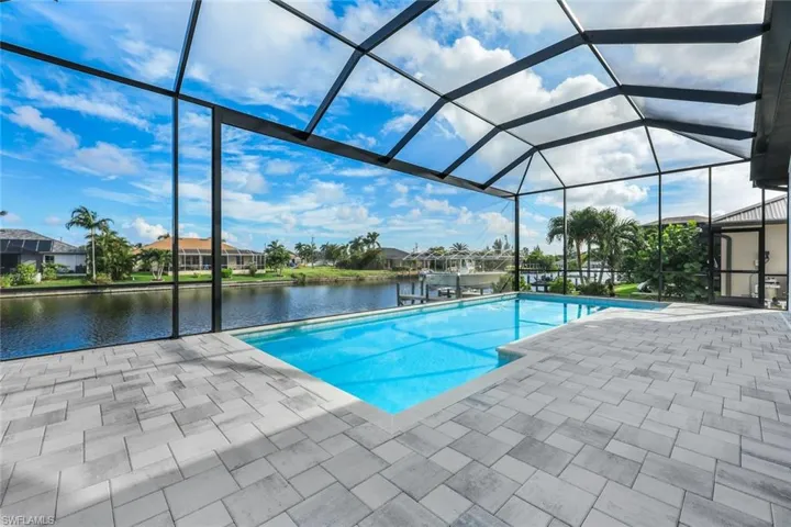View of pool featuring a lanai, a water view, and a patio area