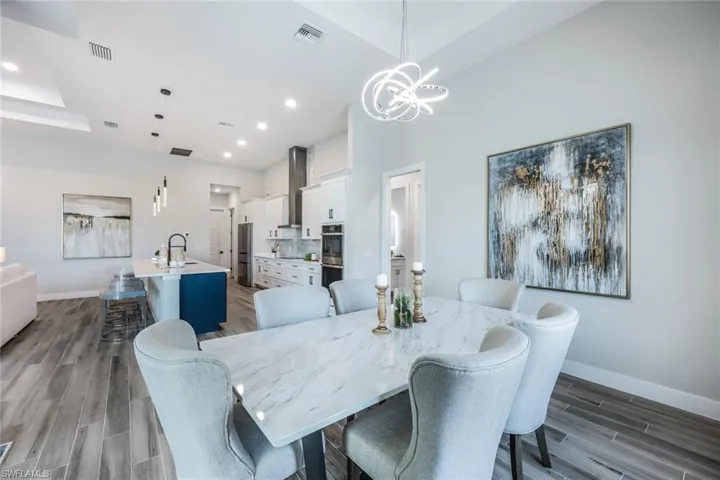 Dining area with hardwood / wood-style floors, sink, and a notable chandelier
