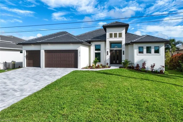 View of front of property featuring a garage and a front yard