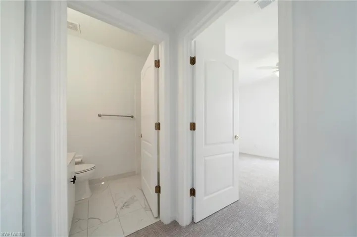 Bathroom featuring toilet and light marble finish floors