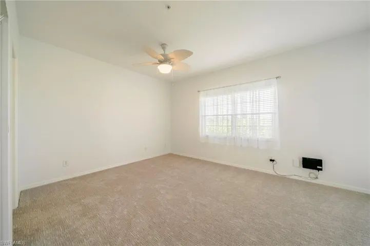 Empty room with light carpet and ceiling fan