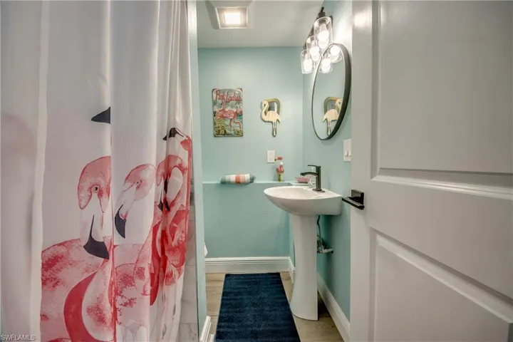 Full bathroom with light wood-style floors and a shower with curtain