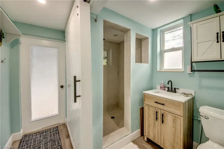 Bathroom with vanity, a shower stall, and light wood-style floors
