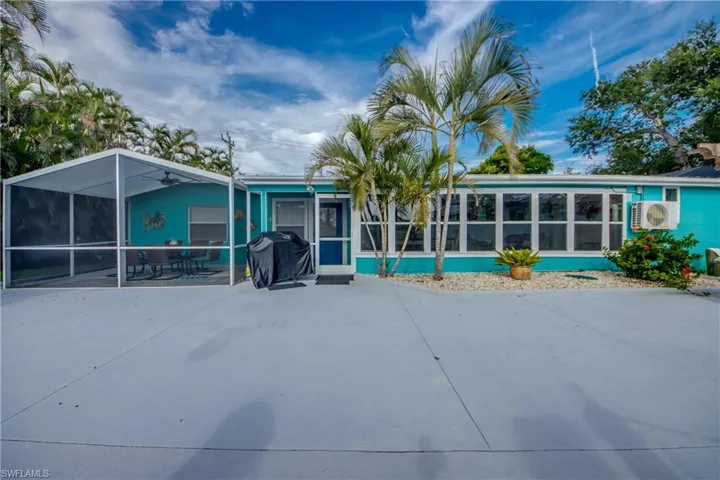 Back of house with a sunroom and a patio