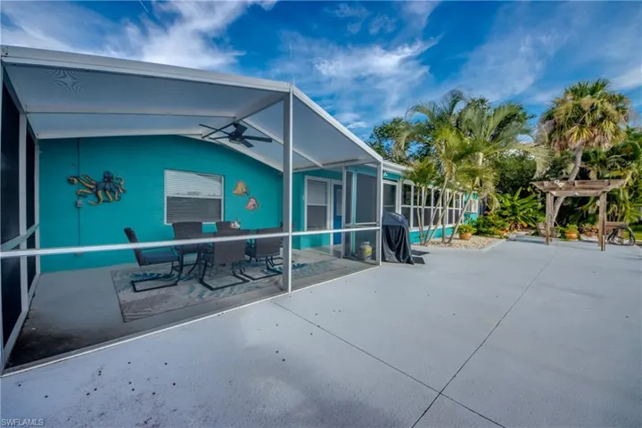 View of patio / terrace featuring a sunroom, glass enclosure, a ceiling fan, outdoor dining area, and an outdoor pool