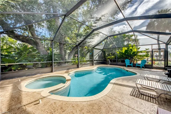 View of swimming pool with a sunroom, a lanai, a pool with connected hot tub, and a patio area