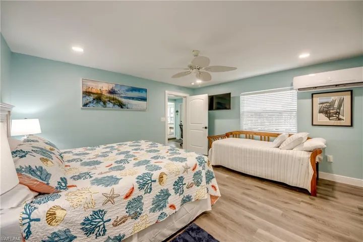 Bedroom featuring an AC wall unit, wood finished floors, ceiling fan, and recessed lighting