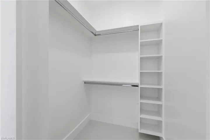 Walk in closet featuring light marble finish floors
